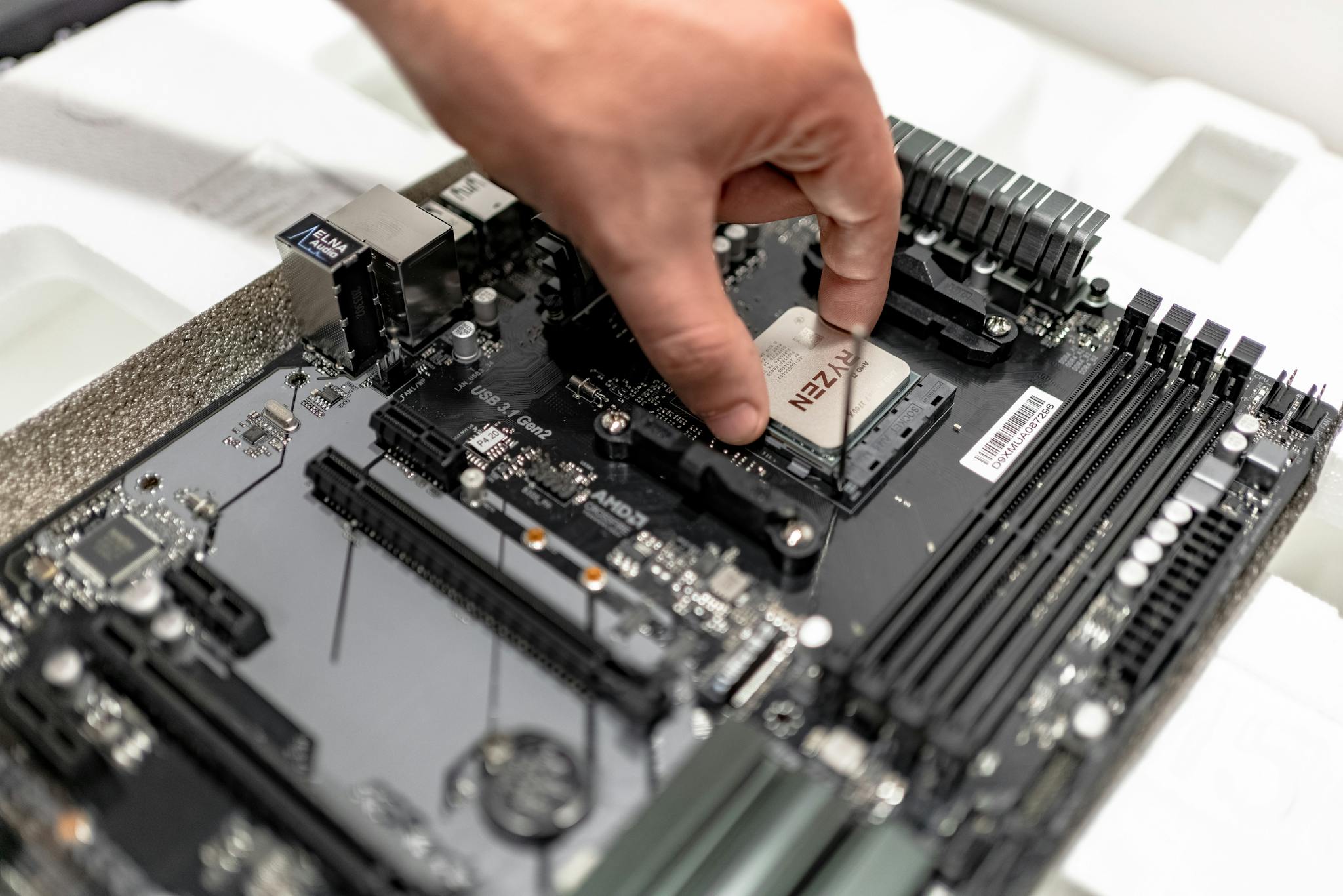 Person's hand installing a CPU on a motherboard, showcasing PC maintenance and repair.